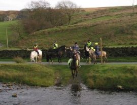 horse riders fording a river